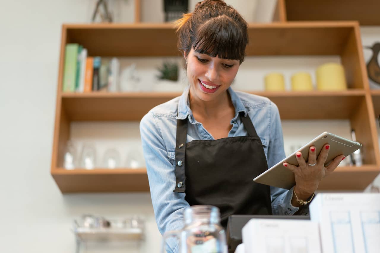 Smiling employee using a Square alternative at checkout.