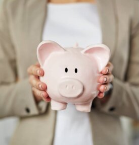 Small business owner looking for business funding while holding a piggy bank.