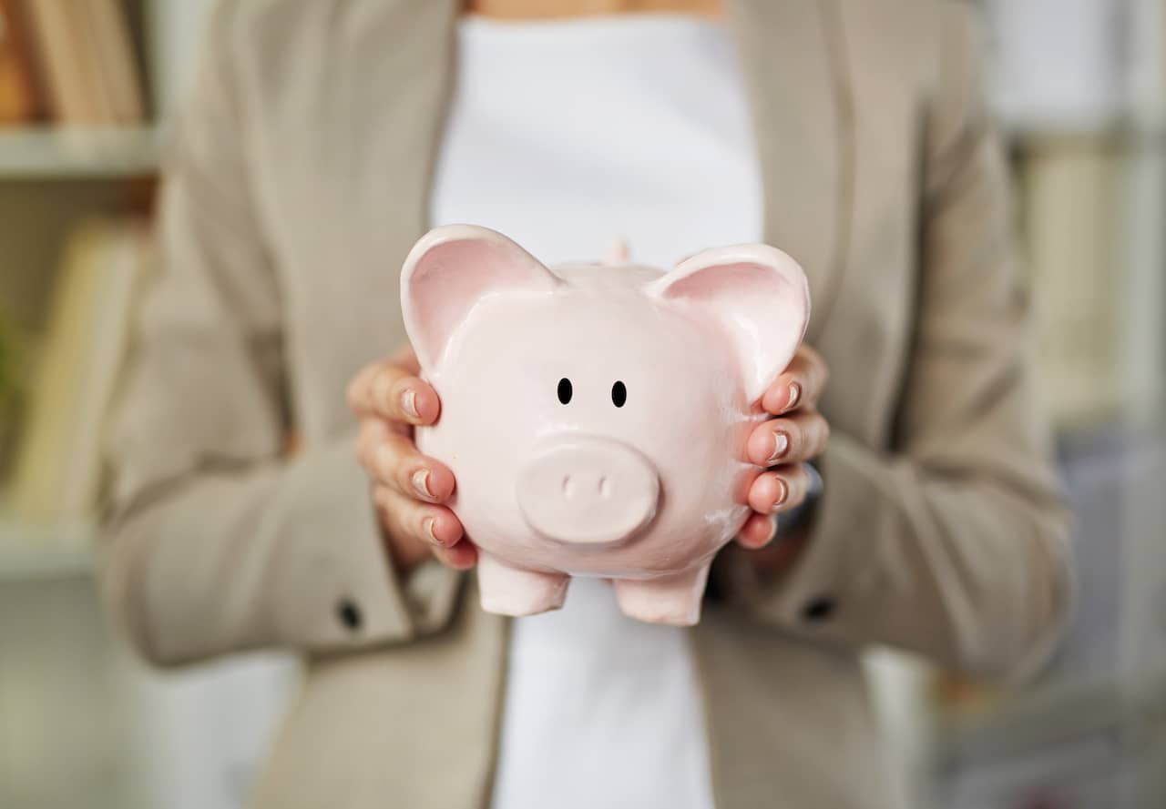 Small business owner looking for business funding while holding a piggy bank.