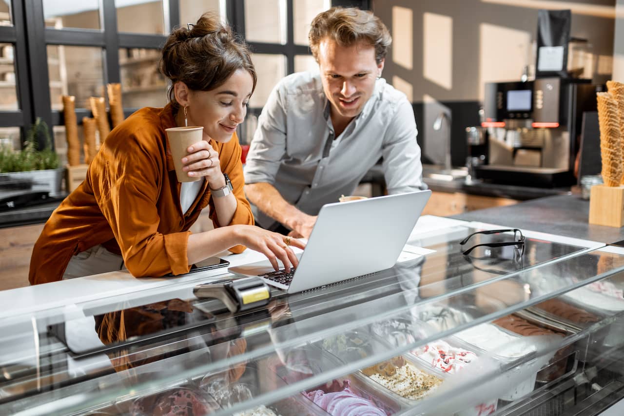 Small business owners researching grants in Arizona on a laptop.